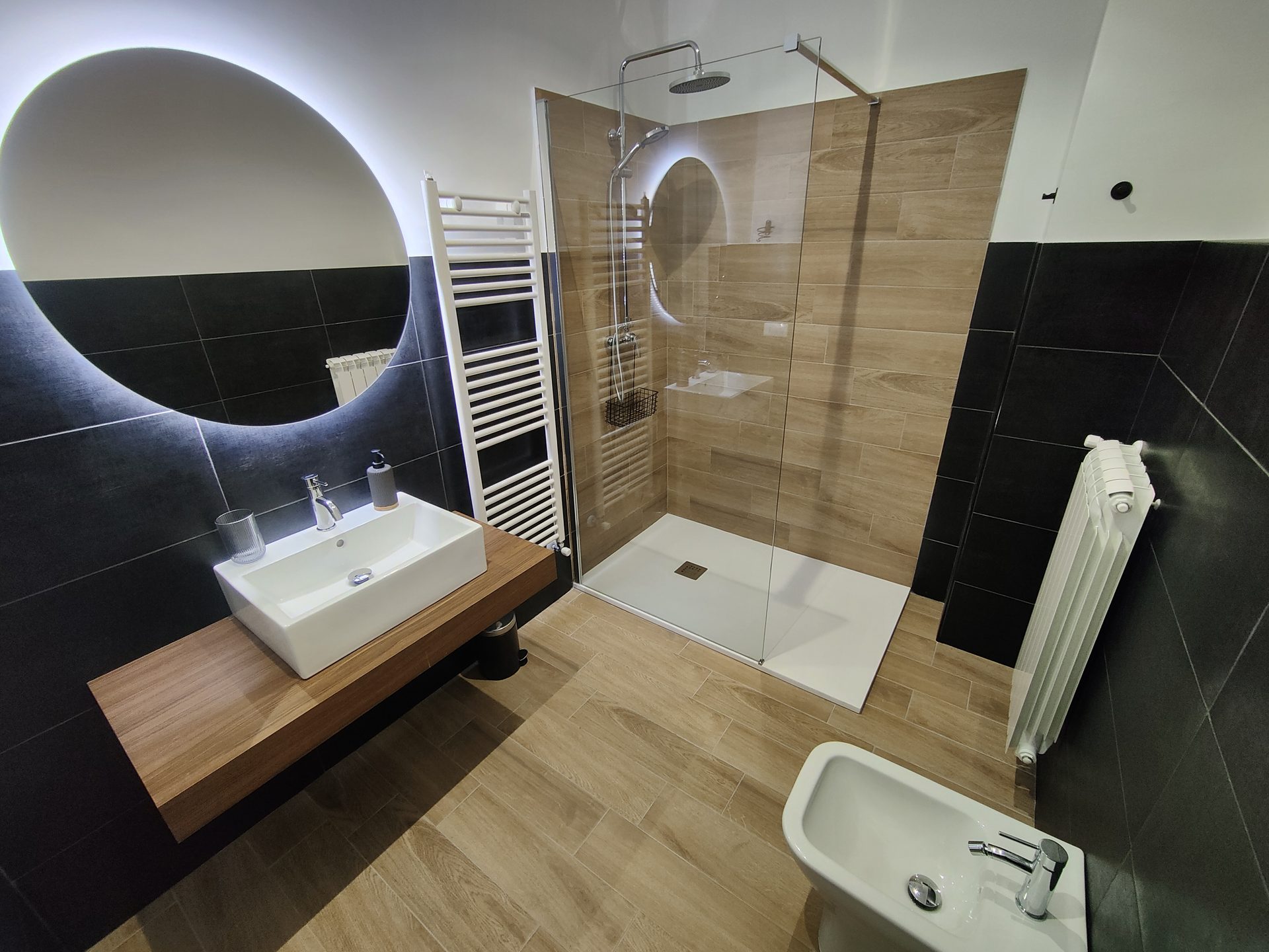 Bagno privato con doccia walk-in, specchio tondo LED e lavabo su mensola in legno, Camera Porta Napoli, B&B a Lecce