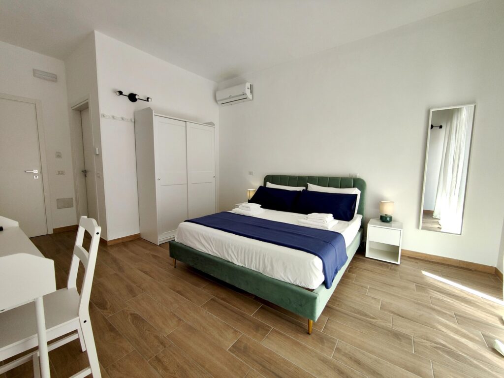 Camera matrimoniale luminosa con armadio, specchio e aria condizionata in B&B a Lecce