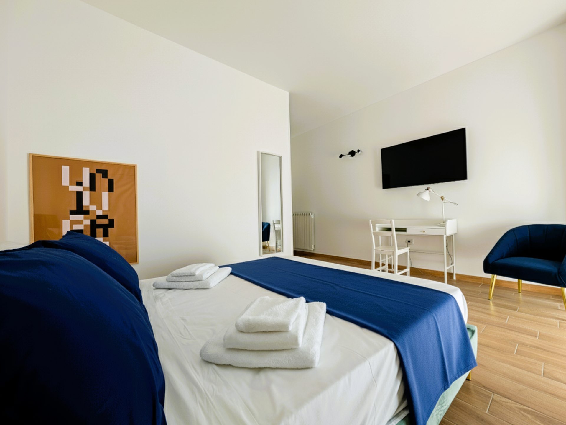 Camera Porta Napoli con scrivania, Smart TV a parete e poltroncina blu, B&B a Lecce