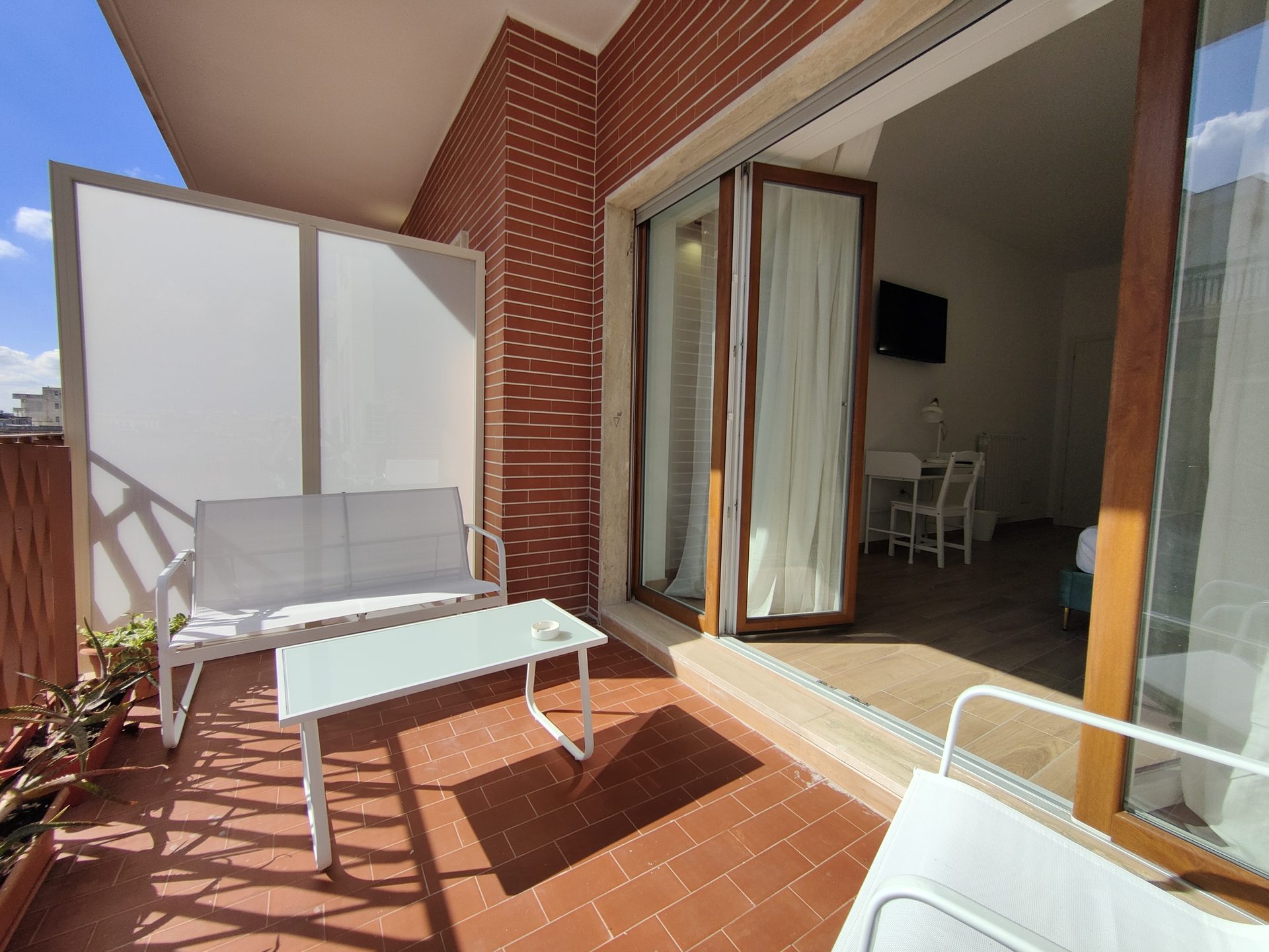 Terrazzino arredato con divanetto e tavolino, accesso diretto dalla camera, B&B a Lecce